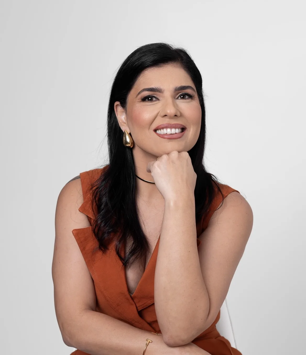 Tatiane Dib sorrindo, com a mão no queixo